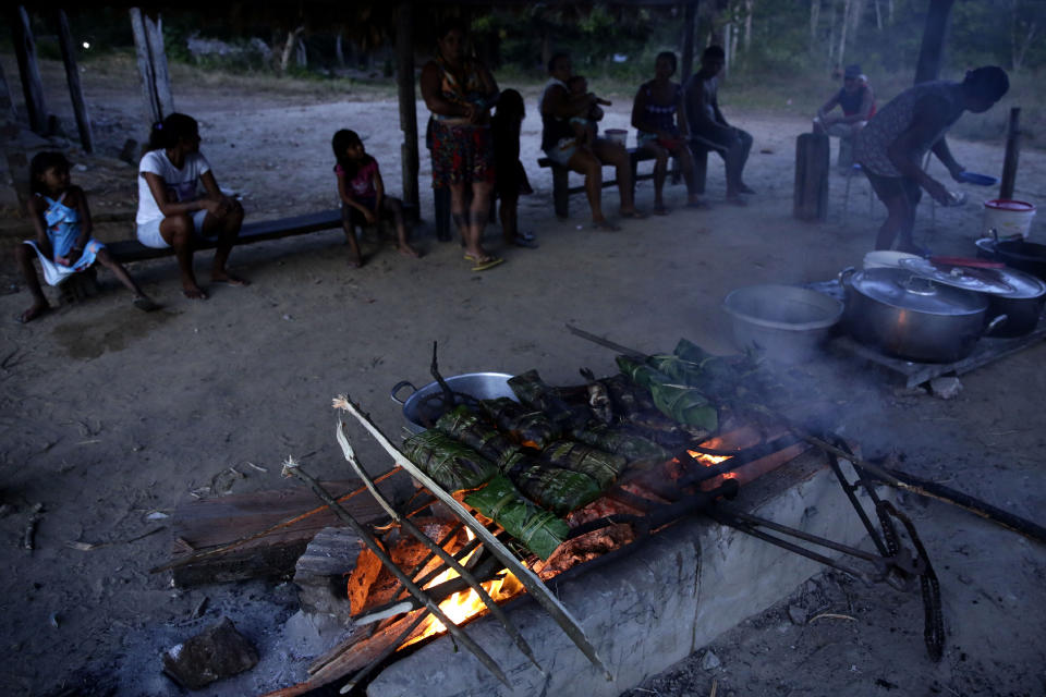 Tenetehara Indigenous women grill fish Moqueada, during a festival in the Alto Rio Guama Indigenous Reserve, where they have enforced six months of isolation during the new coronavirus pandemic, near the city of Paragominas, state of Para, Brazil, Monday, Sept. 7, 2020. The Indigenous group, also known as Tembe, are celebrating and giving thanks that none of their members have fallen ill with COVID-19, after closing their territory from outsiders since March. (AP Photo/Eraldo Peres)