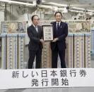 Japanese Prime Minister Fumio Kishida, right, and Bank of Japan Governor Kazuo Ueda hold the country’s new banknotes in a frame, during a ceremony to mark the release of the banknotes, at the BOJ headquarters in Tokyo, Japan, Wednesday, July 3, 2024. The words at bottom read: New Bank of Japan banknotes start being issued. (Japan Pool/Kyodo News via AP)