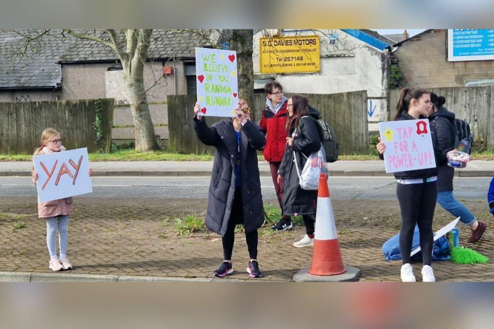 South Wales Argus: Spectators holding signs of encouragement for runners