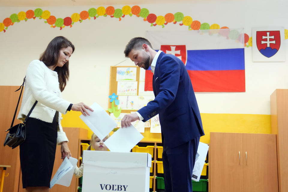 CORRECTS TO PARTNER SONA Leader of Progressive Slovakia party Michal Simecka, right, accompanied with his partner Sona and daughter Tana, casts his vote at a polling station during an early parliamentary election in Bratislava, Slovakia, Saturday, Sept. 30, 2023. (AP Photo/Petr David Josek)