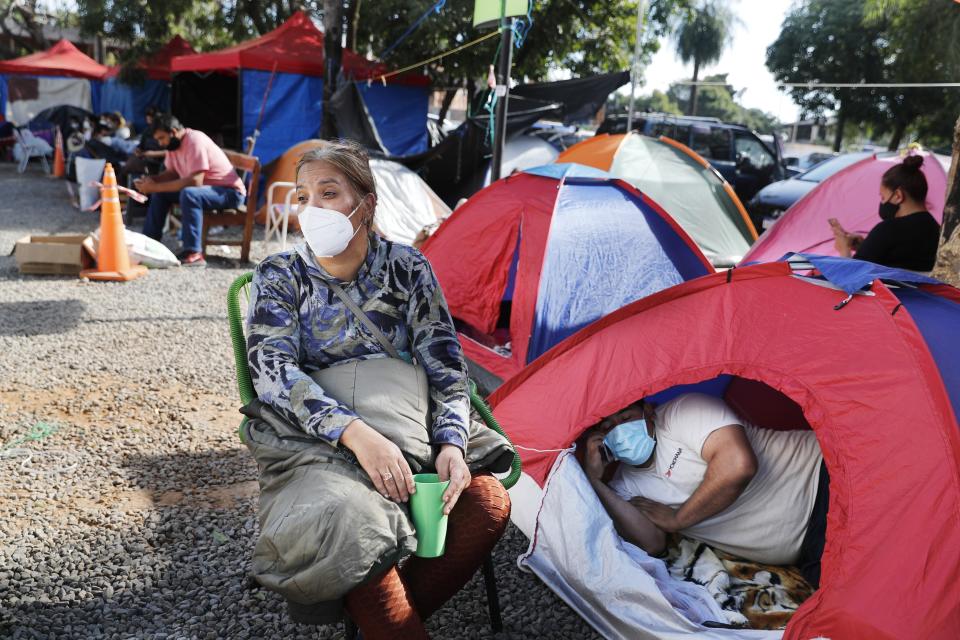 Relatives of COVID-19 patients camp outside the Ingavi Hospital in San Lorenzo, Paraguay, Wednesday, June 2, 2021. The relatives maintain a round-the-clock vigil to provide the food and medicines for their hospitalized family members. (AP Photo/Jorge Saenz)