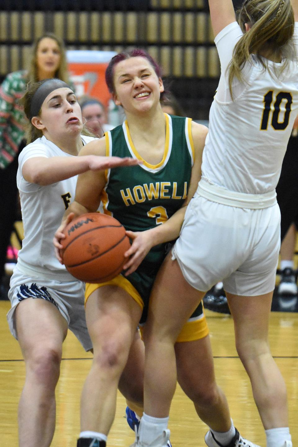 Howell's Sophie Daugard (3), who scored 22 points, tries to get between Hartland defenders Liv Linden (left) and Ellie Laier on Thursday, Dec. 22, 2022.