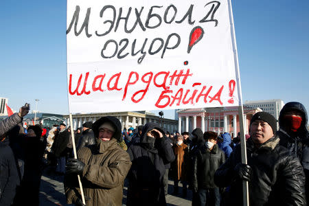 Protesters attend a demonstration to demand the resignation of Mongolia's parliamentary speaker Enkhbold Miyegombo, at Sukhbaatar Square in Ulaanbaatar, Mongolia December 27, 2018. The sign reads, "We demand Enkhbold to resign!" REUTERS/B. Rentsendorj