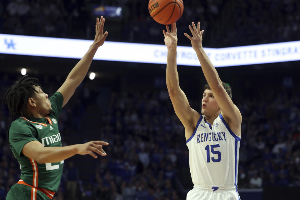 Kentucky's Reed Sheppard (15) shoots while defended by Miami's Nijel Pack, left, during the first half of an NCAA college basketball game in Lexington, Ky., Tuesday, Nov. 28, 2023. (AP Photo/James Crisp)