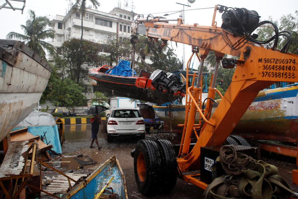 A boat is lifted by a crane off the coast of the Arabian sea as cyclone Nisarga makes its landfall on the outskirts of the city in Mumbai on June 3, 2020. REUTERS/Francis Mascarenhas