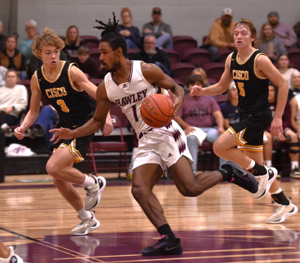 Hawley's Diontay Ramon, center, brings the ball up court as Cisco's Rezner Wilks (3) and Cole Thompson defends in the first half. Hawley beat the Loboes 45-42 in the District 10-2A game Friday in Hawley.