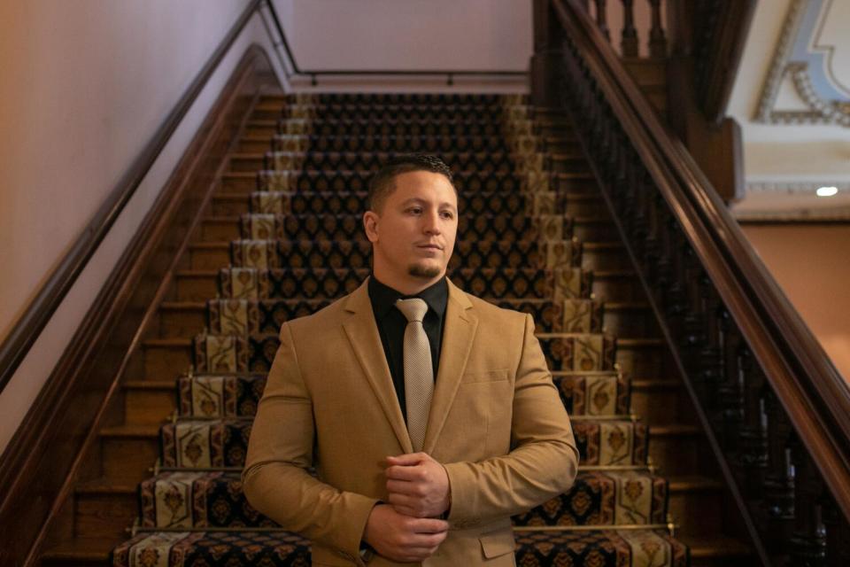 A man stands at the bottom of a flight of stairs.