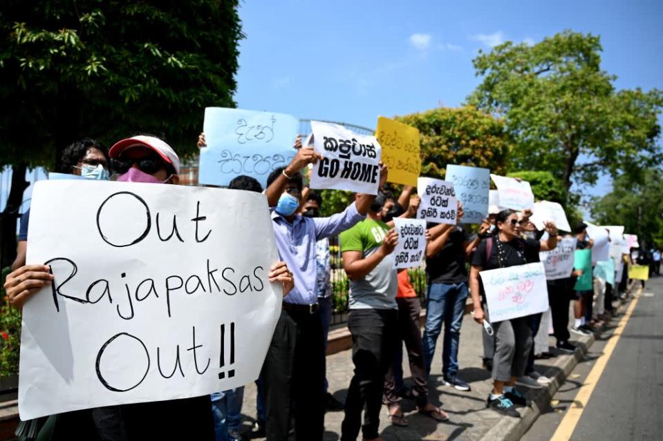 Protestors hold banners and placards during a demonstration against the surge in prices and shortage of fuel and other essential commodities in Colombo on April 4, 2022 - Sri Lanka's president offered to share power with the opposition on April 4, as protests escalated across the country demanding his resignation over worsening shortages of food, fuel and medicines. (Photo by Ishara S. KODIKARA / AFP) (Photo by ISHARA S. KODIKARA/AFP via Getty Images)