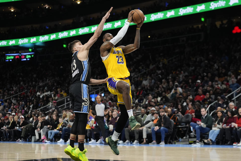 Los Angeles Lakers forward LeBron James (23) goes to the basket as Atlanta Hawks guard Bogdan Bogdanovic (13) defends in the second half of an NBA basketball game Tuesday, Jan. 30, 2024, in Atlanta. (AP Photo/John Bazemore)