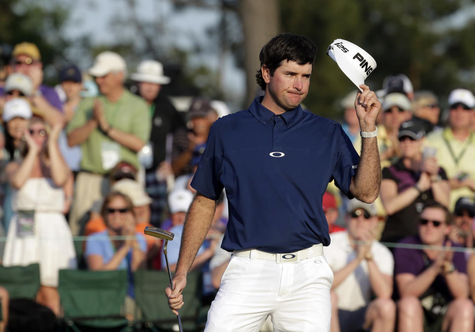 Bubba Watson se quita la gorra para agradecer los aplausos tras realizar su putt en el hoyo 18, durante la tercera ronda del Masters de Augusta, el sábado 12 de abril de 2014 (AP Foto/Charlie Riedel)