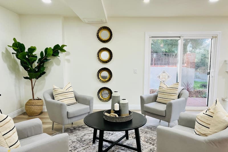 Arm chairs around coffee table in staged living room.