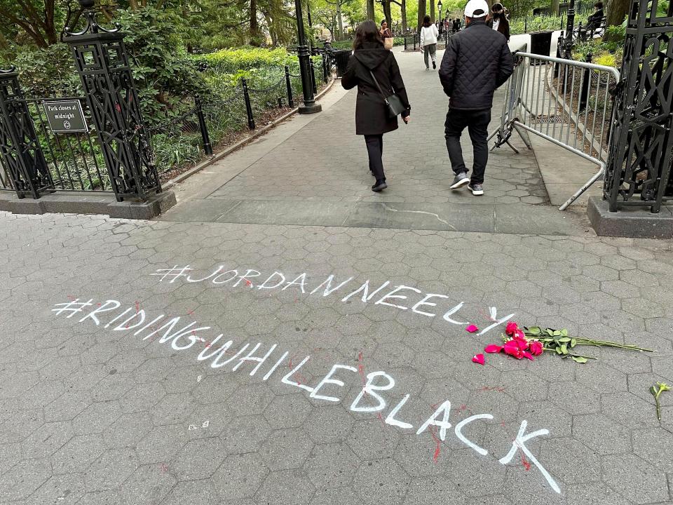 People walk past graffiti calling attention to death of Jordan Neely that was painted on the sidewalk at an entrance to Washington Square Park on, May 5, 2023, in New York.