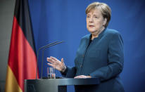 German Chancellor Angela Merkel speaks at a press conference about coronavirus, in Berlin, Sunday, March 22, 2020. German authorities have issued a ban on more than two people meeting outside of their homes, which they believe will be easier to follow than locking people in their homes. The vast majority of people recover from the new coronavirus. According to the World Health Organization, most people recover in about two to six weeks, depending on the severity of the illness. (Michael Kappeler/Pool photo via AP)