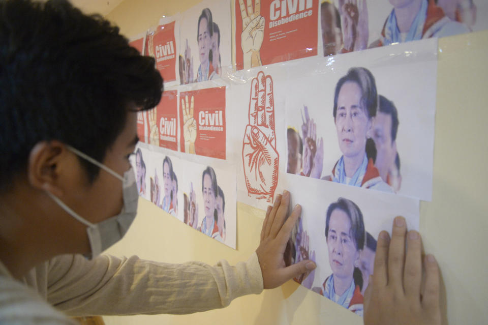 An anti-coup protester looks at the images of ousted Myanmar leader Aung San Suu Kyi during a protest against the military coup in Yangon, Myanmar, on Monday, April 26, 2021. Southeast Asian leaders have demanded an immediate end to killings and the release of political detainees in Myanmar during an emergency summit in Jakarta with its top general and coup leader. (AP Photo)