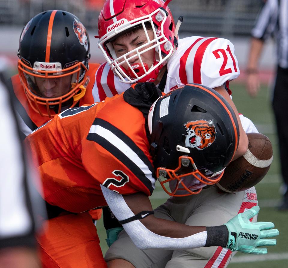 Newton North senior captain Clinton Jacobs causes Waltham junior Tony Ferro to fumble the ball, which was recovered by Newton North junior Brad McNew during the game at Dickinson Stadium in Newton, Sept. 11, 2021.  