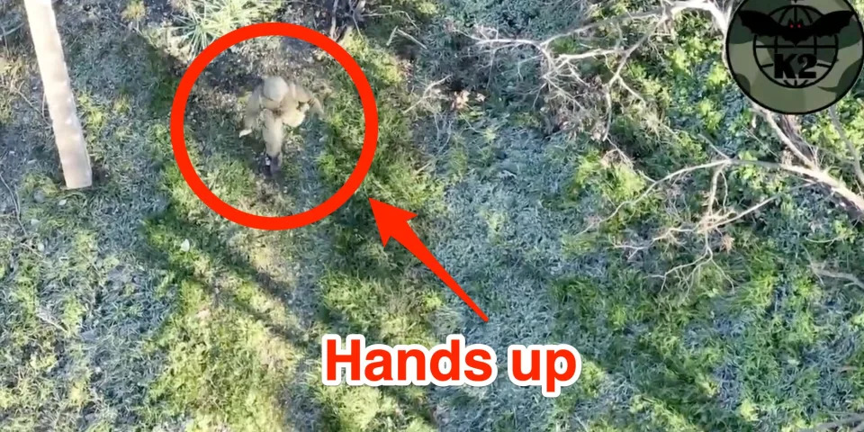 A still from aerial footage shared by the Ukrainian Ministry of Defense, showing a uniformed figure walking with hands up in apparent surrender. Insider marked up the image to highlight the figure and add text saying: "hands up"