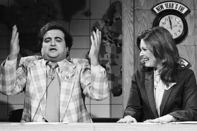 <p>Fred Hermansky/NBC/NBCU Photo Bank/Getty</p> John Belushi (left) and Jane Curtain during Saturday Night Live's Weekend Update on December 2, 1978