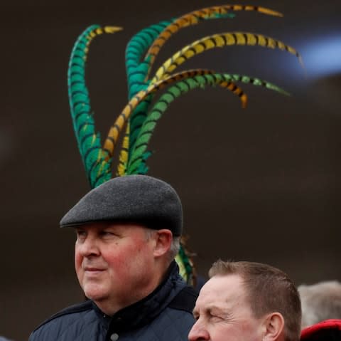 A man with a hat sprouting feathers - Credit: Action Images via Reuters/Andrew Boyers