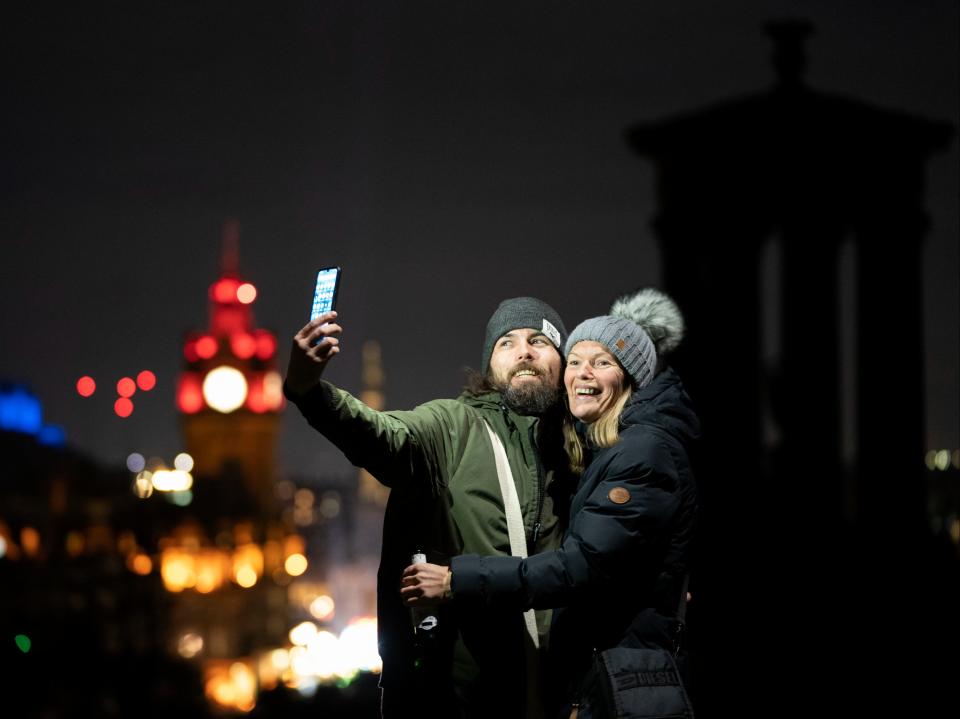 Arthur Grace and Lynsey Gray, from Fife, take a selfie on Edinburgh’s Calton Hill ahead of the bells on New Year’s Eve (Jane Barlow/PA)