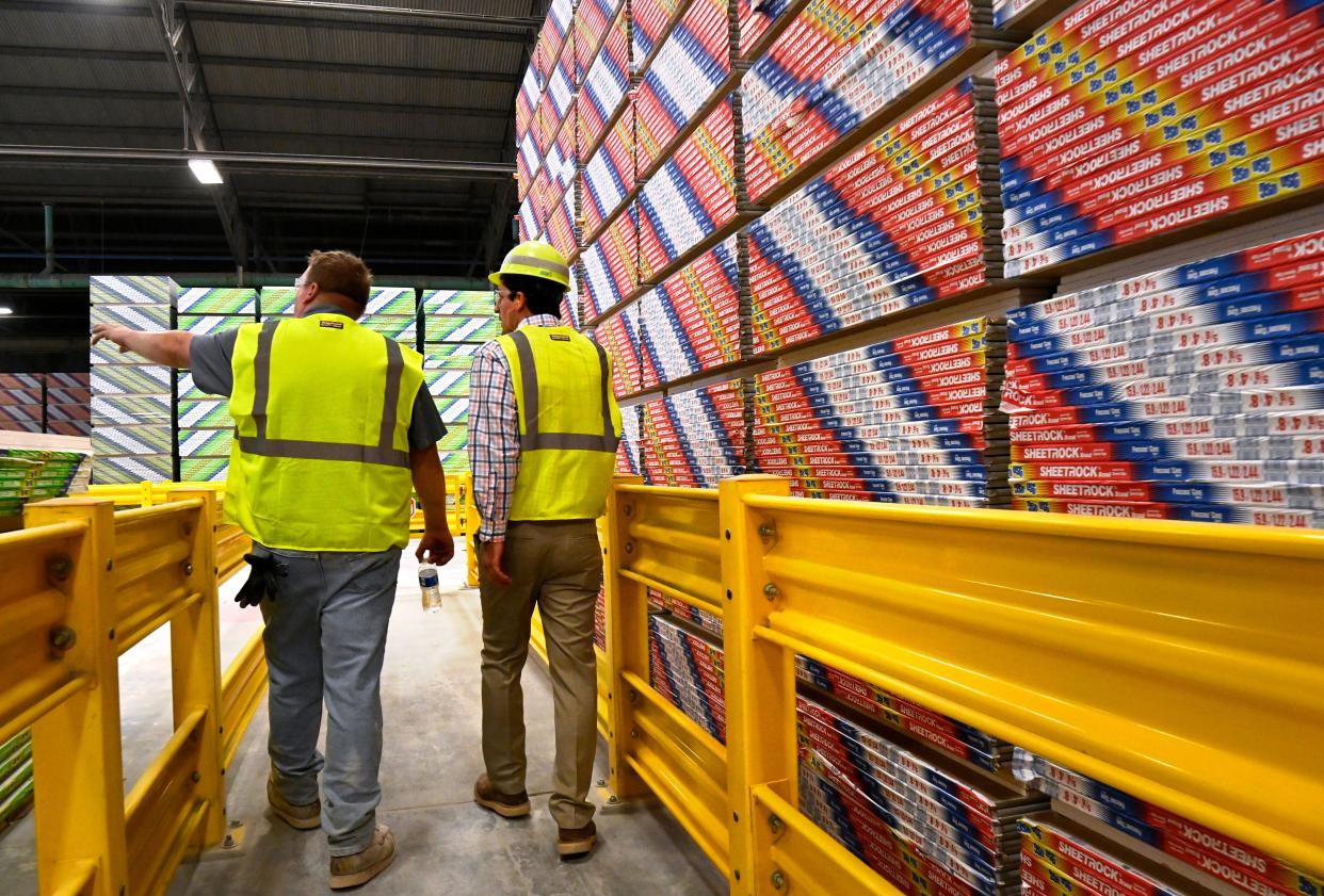 Tobias Calvin points to another stack of wallboards as he and Matt Wills lead a tour through the United States Gypsum warehouse Tuesday. USG is celebrating 100 years in Sweetwater this year.