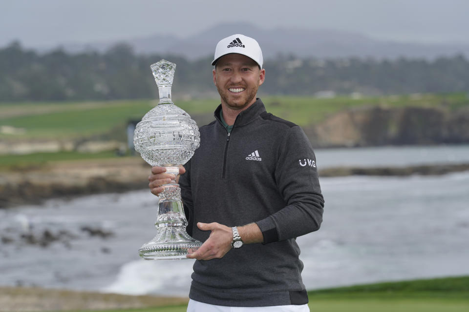 Daniel Berger poses with his trophy on the 18th green of the Pebble Beach Golf Links after winning the AT&T Pebble Beach Pro-Am golf tournament Sunday, Feb. 14, 2021, in Pebble Beach, Calif. (AP Photo/Eric Risberg)