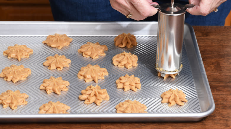 Baker using a cookie press