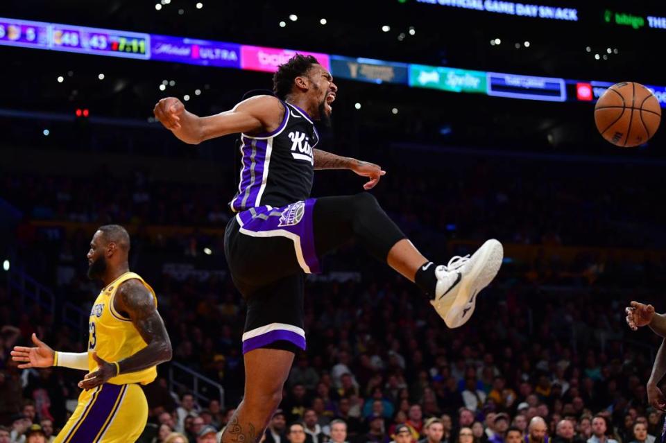 Sacramento Kings guard Malik Monk (0) reacts after dunking for the basket against Los Angeles Lakers forward LeBron James (23) during the first half Wednesday, March 6, 2024, at Crypto.com Arena in Los Angeles.