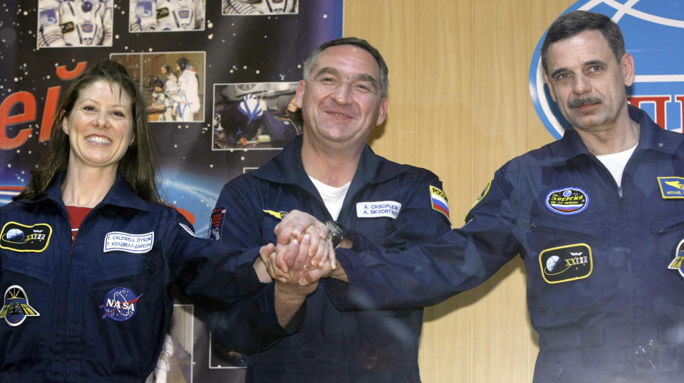 FILE - U.S. astronaut Tracy Caldwell Dyson, left, Russian cosmonauts Alexander Skvortsov, center, and Mikhail Kornienko, right, pose for photographs following their news conference at the Russian-leased Baikonur Cosmodrome, Kazakhstan, Thursday, April 1, 2010. Russia will opt out of the International Space Station after 2024 and focus on building its own orbiting outpost, the country's newly appointed space chief said Tuesday, July 26, 2022. (AP Photo/Misha Japaridze, File)