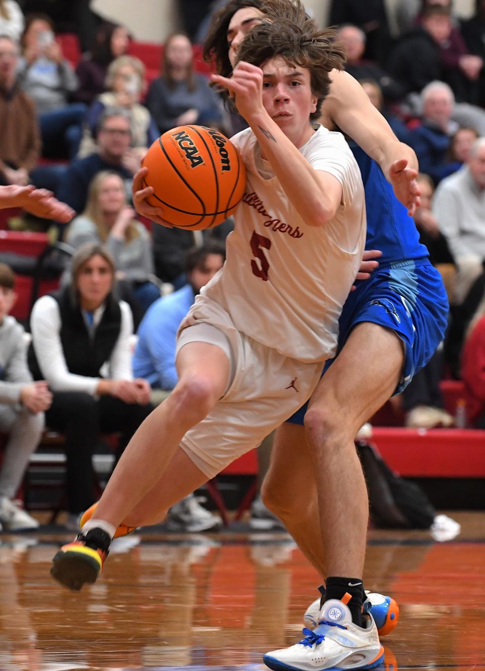 Dewey High School's senior Jace Williams (5) drives the ball during basketball action earlier in the season.