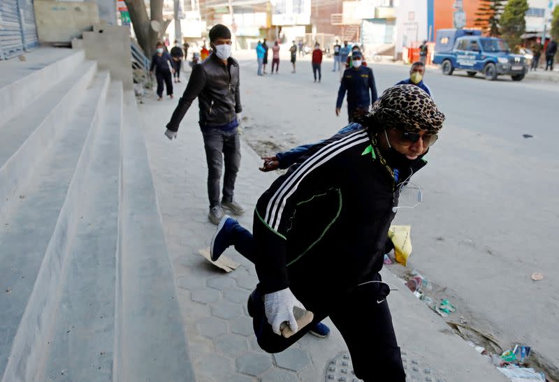 A local protester carries a brick during a protest against Indonesians taking shelter at the mosque, amid fear of outsiders spreading coronavirus disease (COVID-19) at Jame Masjid in Imadol, Lalitpur