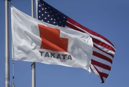 A flag with the Takata logo flies alongside a U.S. flag outside Takata corporation in Auburn Hills, Michigan May 20, 2015. REUTERS/Rebecca Cook