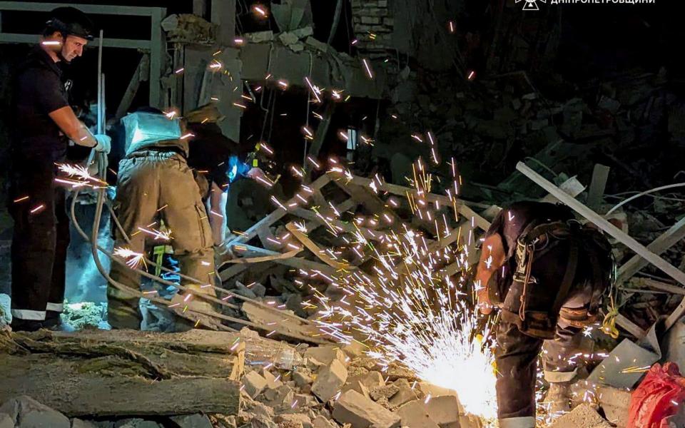 Ukrainian rescuers working at the site of the rocket strike in Kryvyi Rih, central Ukraine