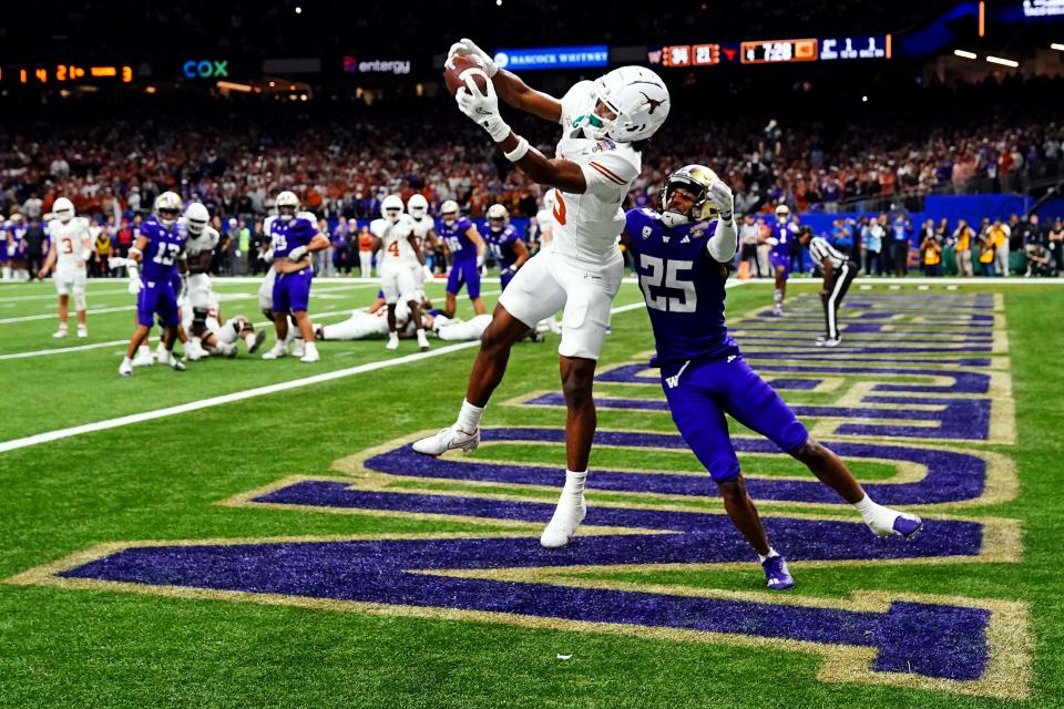 Jan 1, 2024; New Orleans, LA, USA; Texas Longhorns wide receiver Adonai Mitchell (5) catches a touchdown pass against Washington Huskies running back Ryder Bumgarner (25) during the fourth quarter in the 2024 Sugar Bowl college football playoff semifinal game at Caesars Superdome. Mandatory Credit: John David Mercer-USA TODAY Sports