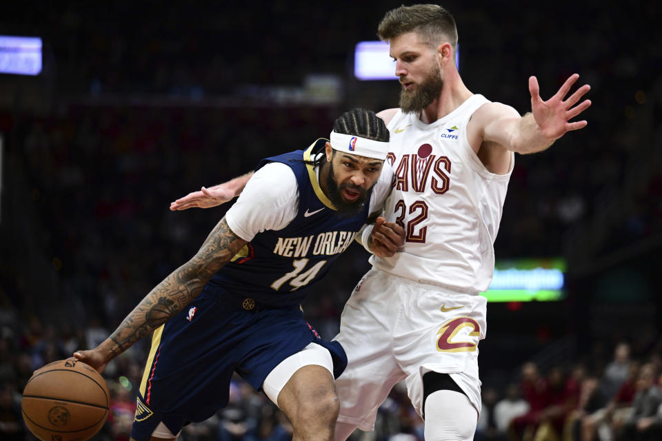 New Orleans Pelicans forward Brandon Ingram, left, drives against Cleveland Cavaliers forward Dean Wade, right, in the second half of an NBA basketball game, Thursday, Dec. 21, 2023, in Cleveland. (AP Photo/David Dermer)