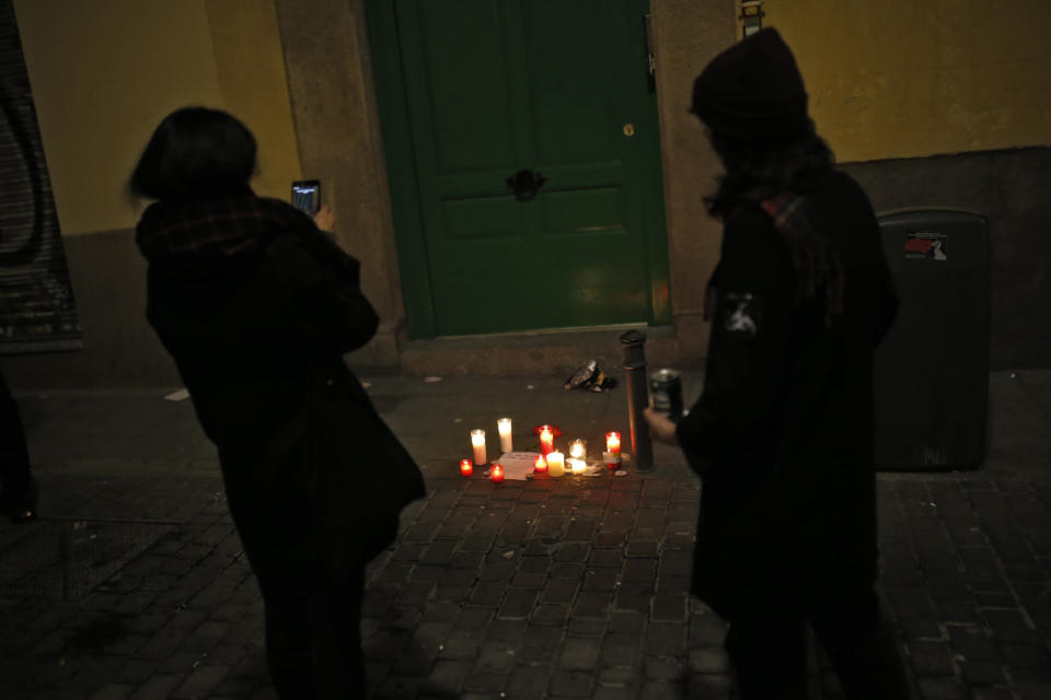 Dos mujeres pasan junto a las velas colocadas en el lugar en el que falleció el mantero (AP).