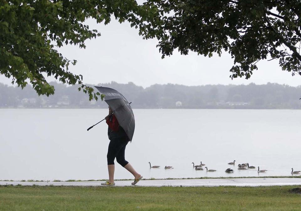 A pedestrian walks on the Spartan Trail along Springfield Lake in Springfield Township.