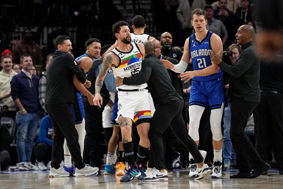 Minnesota Timberwolves guard Austin Rivers, middle, is held back after participating in a scrum with Orlando Magic players during the second half of an NBA basketball game, Friday, Feb. 3, 2023, in Minneapolis.