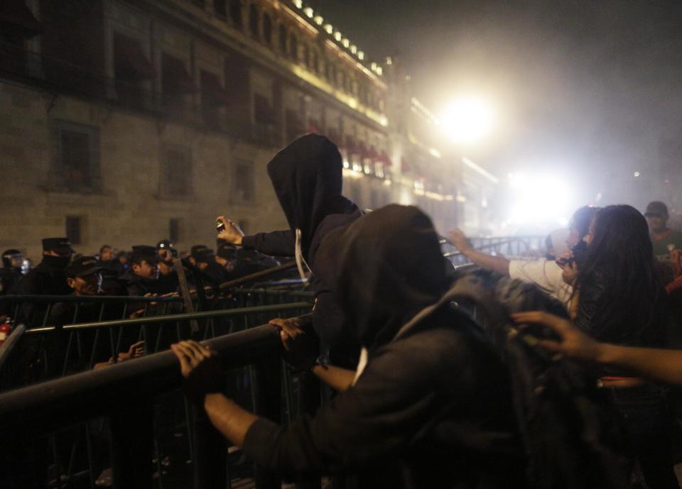 Demonstrators confront riot police outside the ceremonial palace of Mexico's President Enrique Pena Nieto during a protest in support of 43 missing Ayotzinapa students in Mexico City