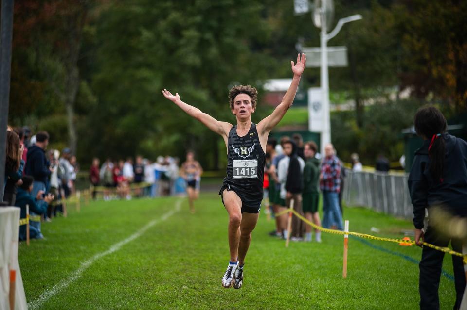 Hackley's Asher Beck celebrates as he hits the finish line to win the first of two boys varsity races during the Brewster Bear Cross-Country Classic in Brewster on Sunday, October 8, 2023.