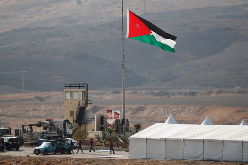 A Jordanian national flag is lifted near a tent at the "Island of Peace" in an area known as Naharayim in Hebrew and Baquora in Arabic, on the Jordanian side of the border with Israel, as seen from the Israeli side