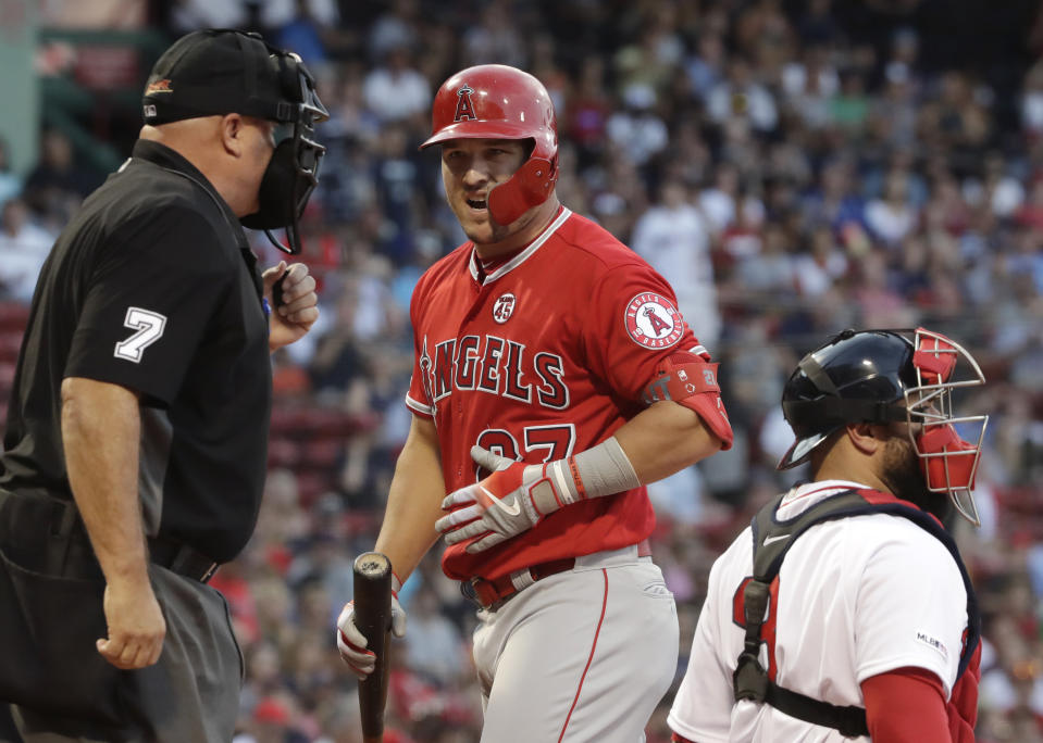 Los Angeles Angels' Mike Trout reacts to home plate umpire Brian O'Nora, who called Trout out on strikes during the first inning of the team's baseball game against the Boston Red Sox at Fenway Park, Thursday, Aug. 8, 2019, in Boston. Red Sox catcher Sandy Leon is at right. (AP Photo/Elise Amendola)