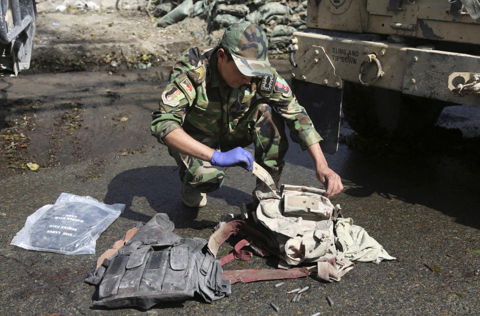 An Afghan Army soldier goes through bullet proved vests found after Taliban insurgents staged a multi-pronged attack on a police station in Jalalabad, eastern Afghanistan, Thursday, March 20, 2014. Taliban insurgents staged the attack, using a suicide bomber and gunmen to lay siege to the station, government officials said. Two remotely detonated bombs also exploded nearby. (AP Photo/Rahmat Gul)