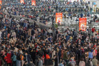 Travelers wearing face masks to protect against COVID-19 line up for trains at a station in Guangzhou in southern China's Guangdong Province, Friday, Jan. 28, 2022. Chinese are traveling to their hometowns for the Lunar New Year, the country's biggest family holiday, despite a government plea to stay where they are as Beijing tries to contain coronavirus outbreaks. (Chinatopix via AP)