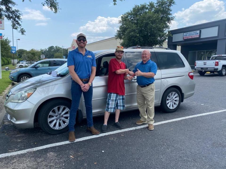 Rocky Harrison with 90Works and Bobby Phillips, a volunteer with the Next Step Vehicles program, hand the keys for a donated Honda Odyssey mini-van to veteran Dylan Clark in July 2023.