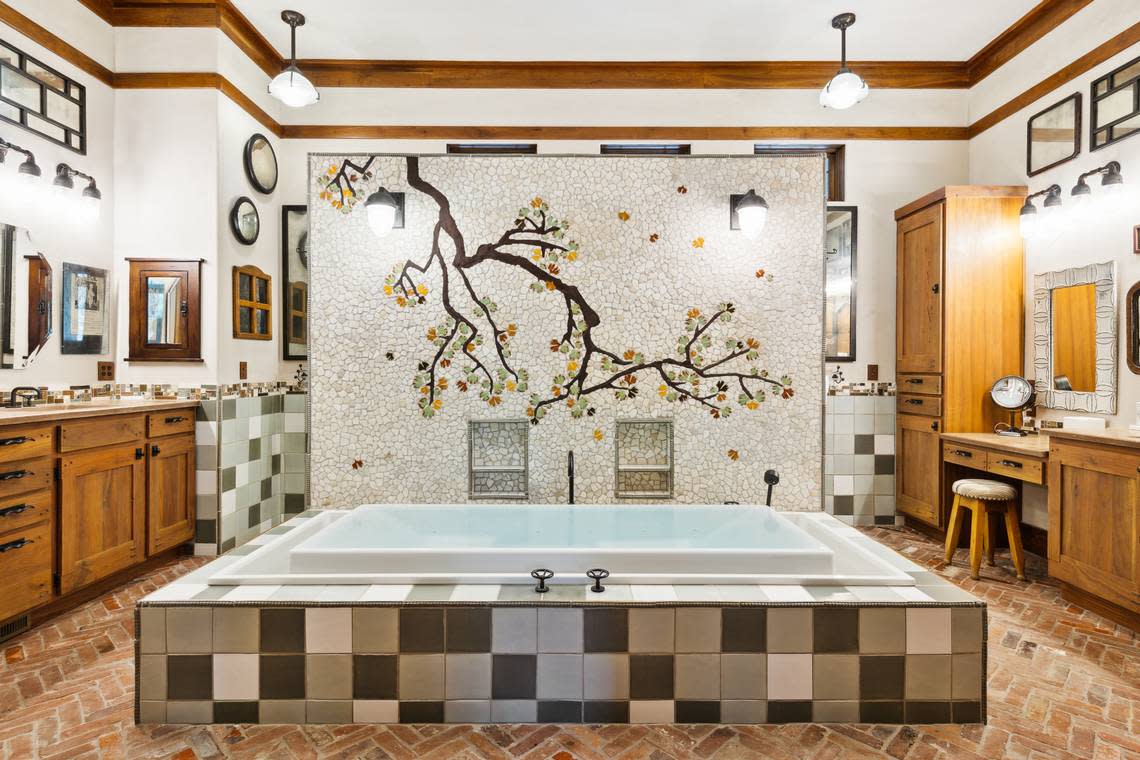 A view of the tile tree mural, which serves as the focal point for the spa-like primary bathroom, found within 36 Plumbridge Circle on Hilton Head Island, SC.
