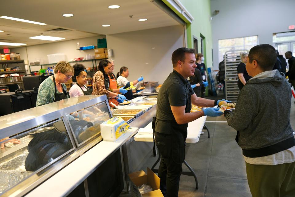 Derrick Ott hands out plates of food Wednesday, Nov. 23, 2022, during a Thanksgiving meal at the Homeless Alliance.