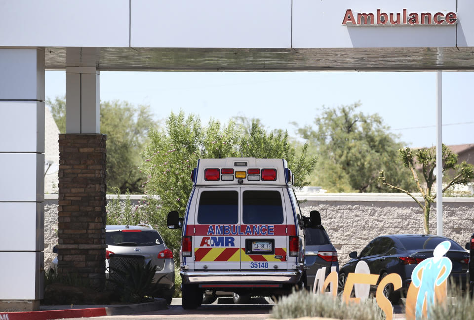 FILE - In this June 10, 2020, file photo, an ambulance is parked at Arizona General Hospital in Laveen, Ariz. Arizona is continuing to see slight downward trends with coronavirus hospitalizations as officials find more related deaths. Arizona is committing millions of dollars and asking the federal government for extra help as hospitals face a growing strain from rising COVID-19 caseloads and warn they are nearing their limits. (AP Photo/Ross D. Franklin, File)