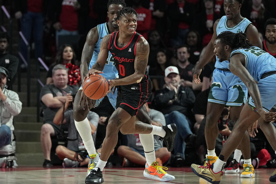 Houston guard Marcus Sasser breaks out of a double-team as Tulane's Kevin Cross (24) and Jalyen Forbes (25) defend during the first half of an NCAA college basketball game Wednesday, Feb. 22, 2023, in Houston. (AP Photo/Kevin M. Cox)