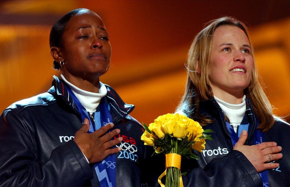 With tears and smiles, Vonetta Flowers, left, and Jill Bakken listen to the American national anthem during an awards ceremony at the Olympic Medals Plaza on Wednesday, Feb. 20, 2002. | Jason Olson, Deseret News