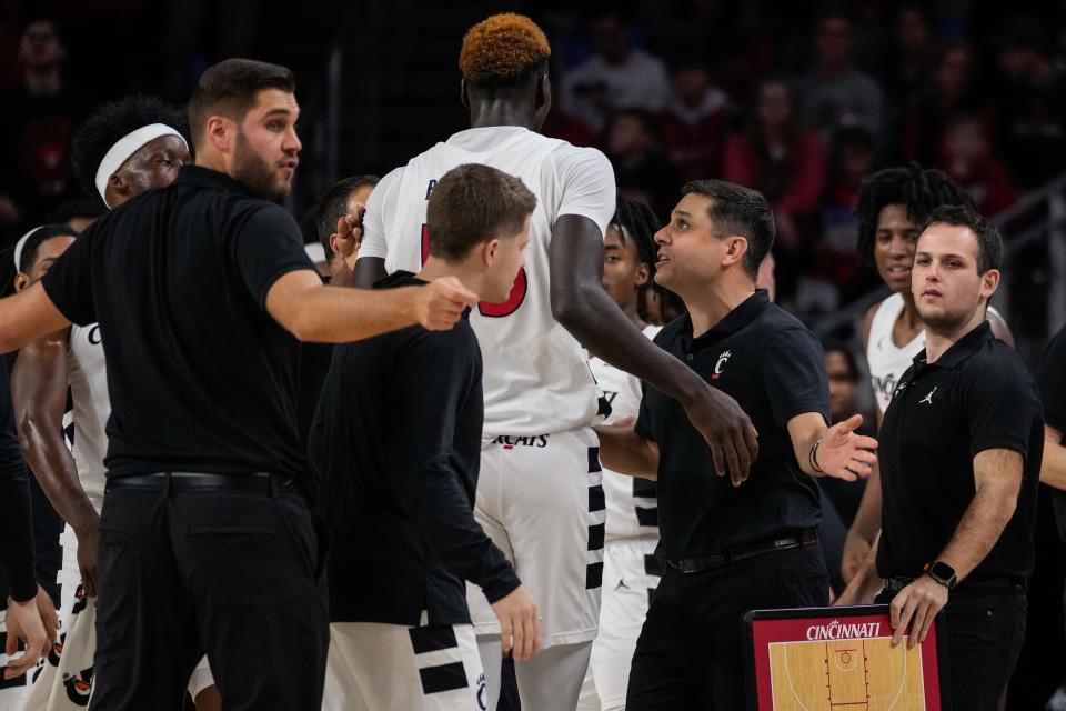 Cincinnati Bearcats head coach Wes Miller cheers on forward Aziz Bandaogo (55) as they enter a timeout in the first half of the NCAA men’s basketball game between the Cincinnati Bearcats and the Florida Gulf Coast Eagles at Fifth Third Arena in Cincinnati on Sunday, Dec. 3, 2023.